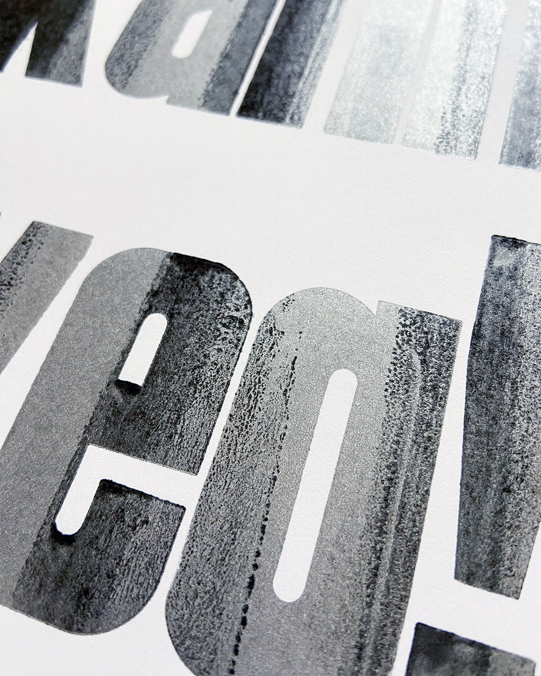 Detailaufnahme des handgedruckten Bleisatzdrucks »Ne, kann weg!« mit markanter schwarzer und silberner Typografie auf weißem Papier.