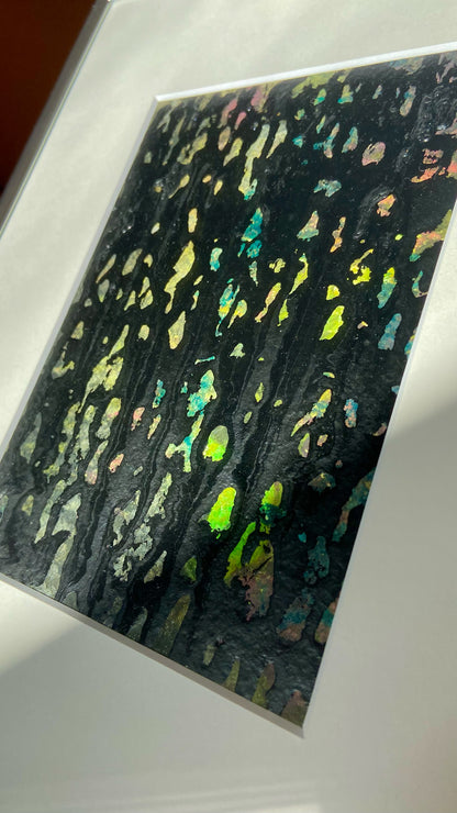 Nahaufnahme einer mehrfarbigen Chirografie in Acryl und Kreide auf Karton, gerahmt mit Passepartout und Aluminiumrahmen, partiell mit Sonnenlicht beleuchtet