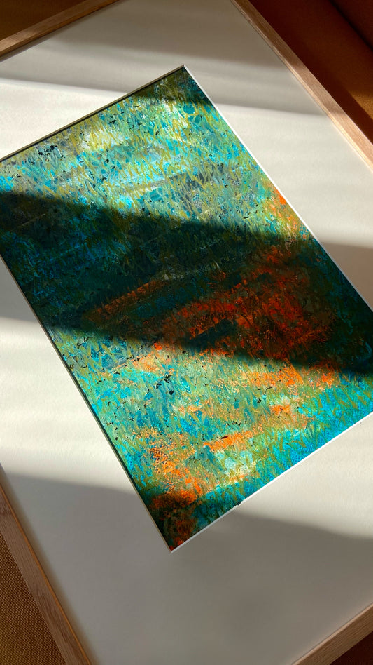 Mehrfarbige Chirografie in Ölpastell und Kreide auf Karton, gerahmt mit Passepartout und Holzrahmen, liegend auf gelbem Polster, partiell mit Sonnenlicht beleuchtet