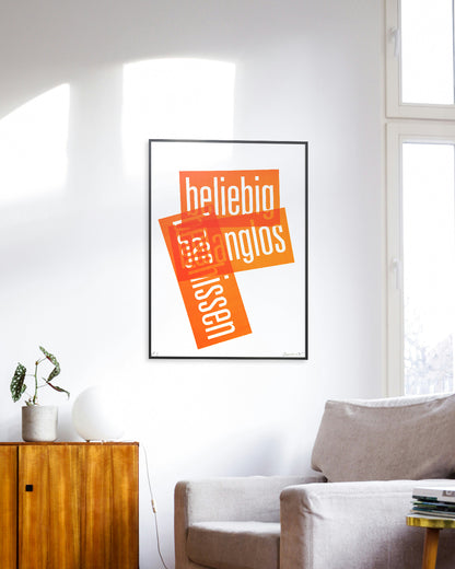 Siebruck mit den Worten »beliebig«, »belanglos« und »beschissen« in Neonorange, gesetzt in schmaler Groteskschrift auf weißem Karton, gerahmt mit schwarzem Rahmen an Zimmerwand, im Vordergrund ein grauer Sessel und eine braune Kommode