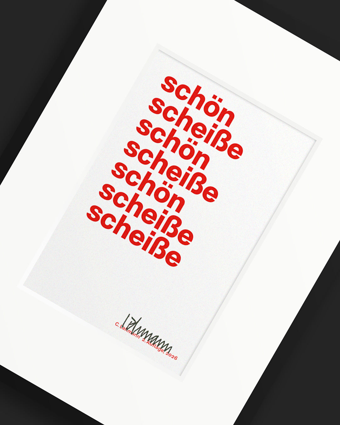 Schräg fotografierter roter Siebdruck »schön scheiße« im weißen Passepartout und schwarzen Rahmen.