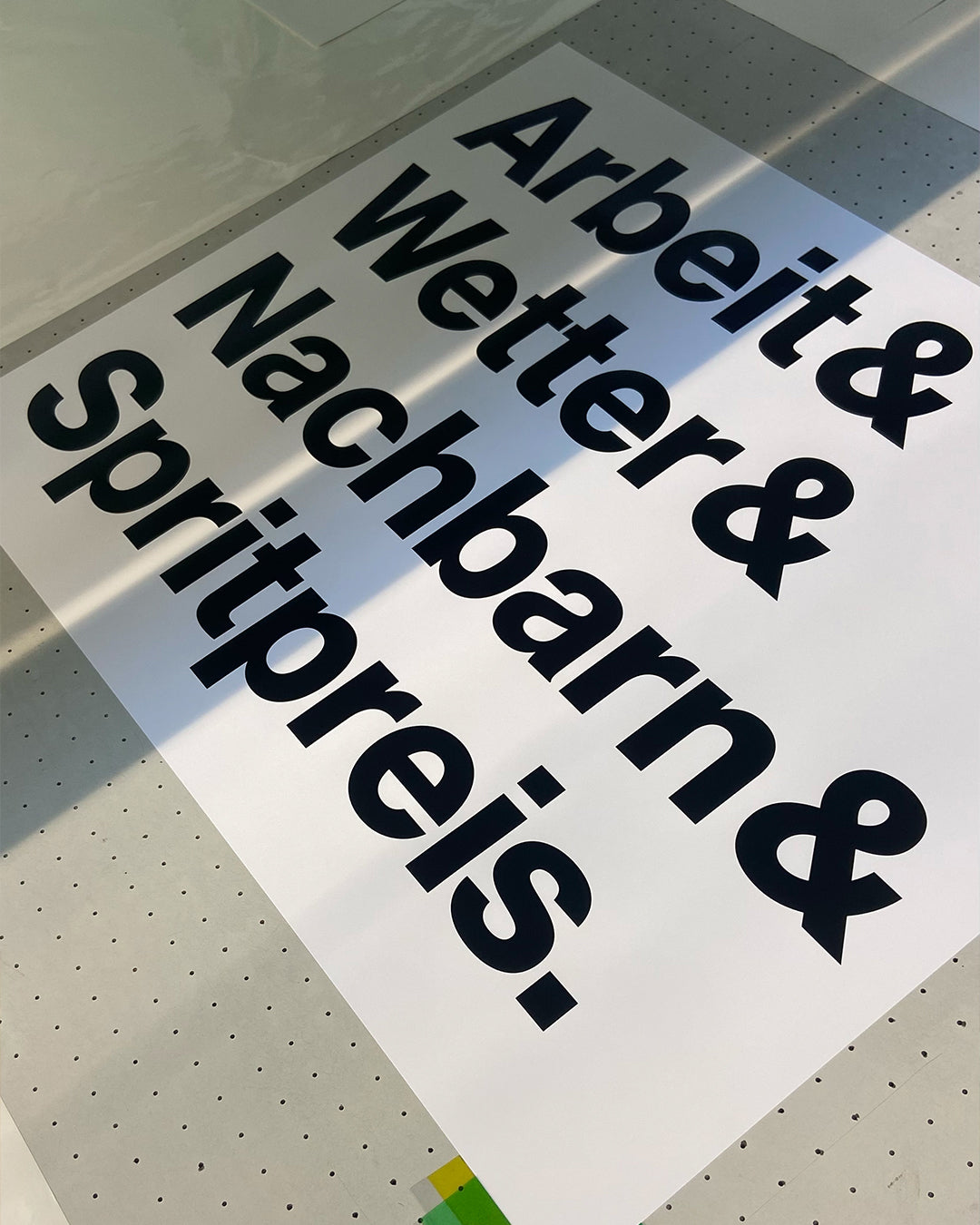 Frisch gedruckter Siebdruck »Arbeit & Wetter & Nachbarn & Spritpreis.« in der Druckwerkstatt.