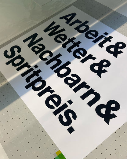 Frisch gedruckter Siebdruck »Arbeit & Wetter & Nachbarn & Spritpreis.« in der Druckwerkstatt.