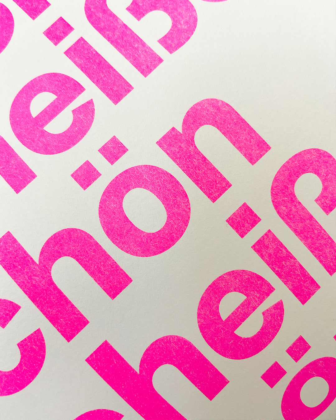 Detailaufnahme des RISO-Druckes der pinken Groteskschrift auf cremefarbenen Papier